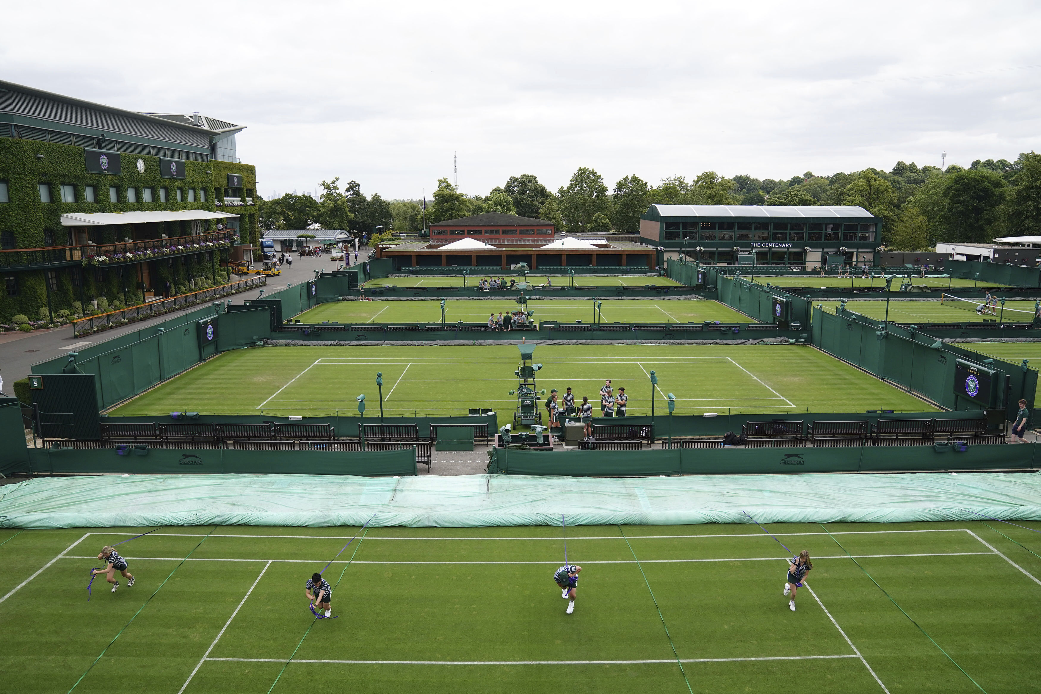Ground staff practice moving the covers on the outside courts at the All England Lawn Tennis and Croquet Club in Wimbledon, London, Britain, ahead of the championships starting tomorrow, on Sunday, July 2, 2023. 