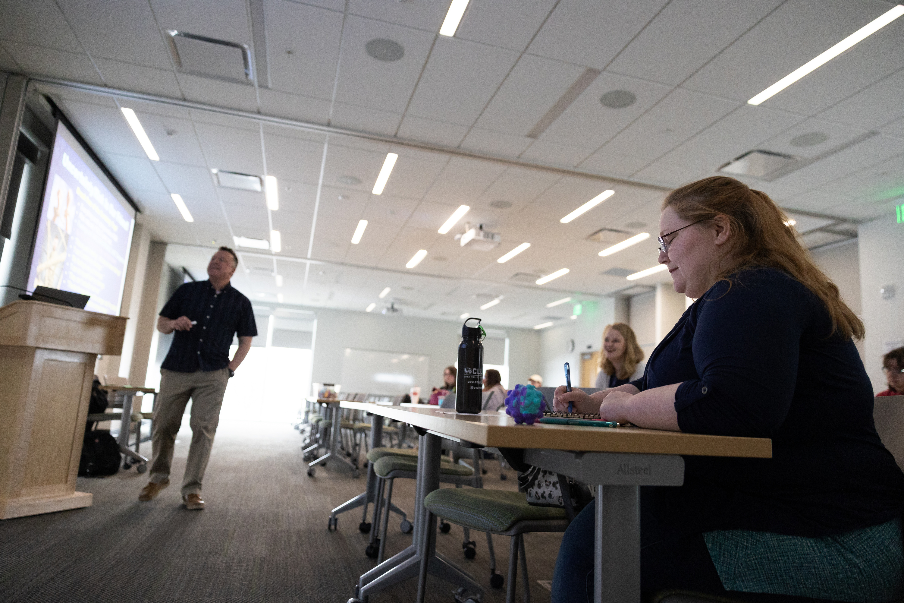 Rachel Leonard takes notes as adjunct professor Jared Stewart teaches at the Melisa Nellesen Center for Autism in Orem on April 3. A report highlights gaps in services for adults with autism in Utah.