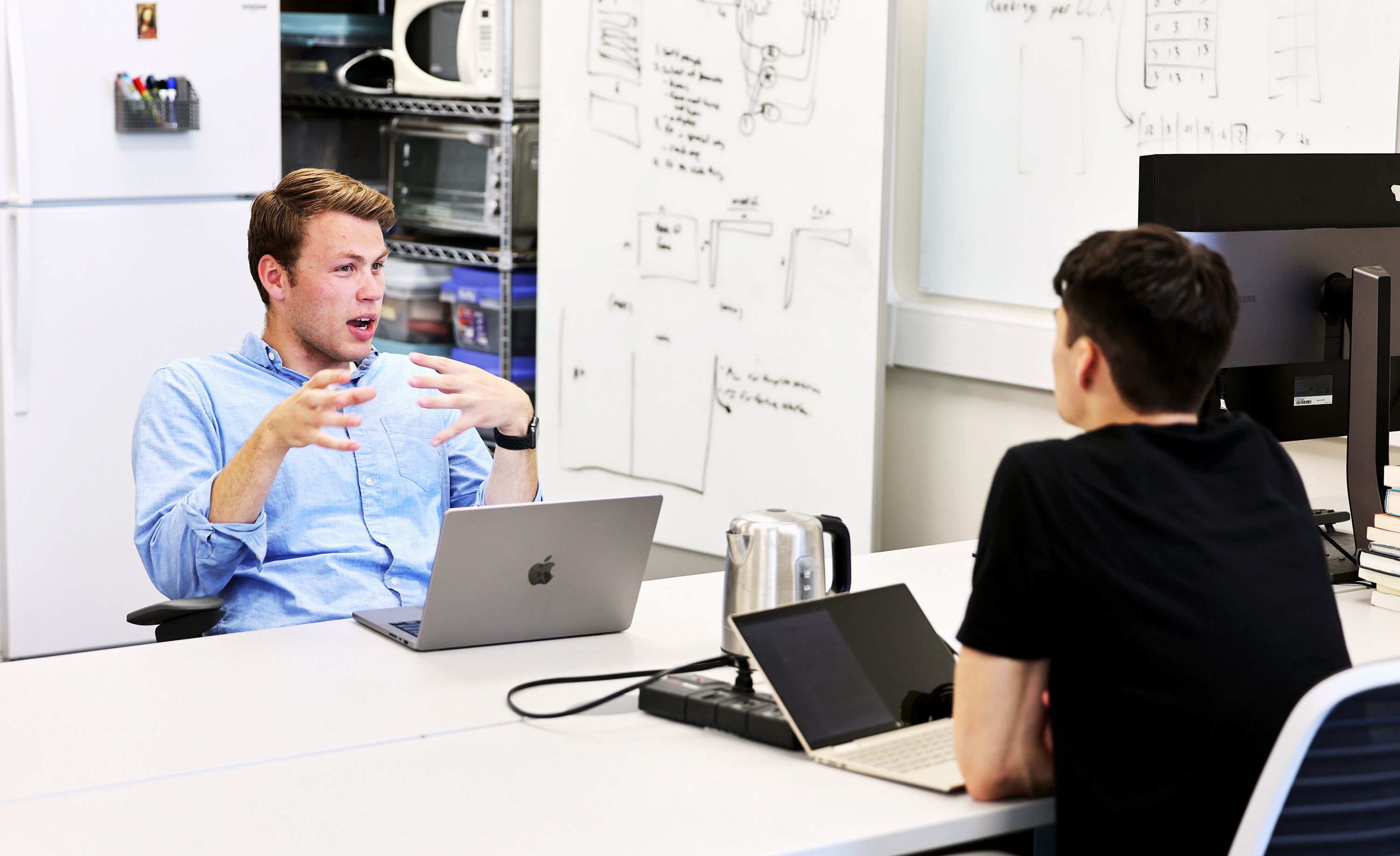 BYU students Cameron Birrell and Jonathan Chelius talk as they and other students work in the Perception, Control and Cognition lab at BYU on June 30. BYU students will this fall be able to major in machine learning — the technology behind ChatGPT.