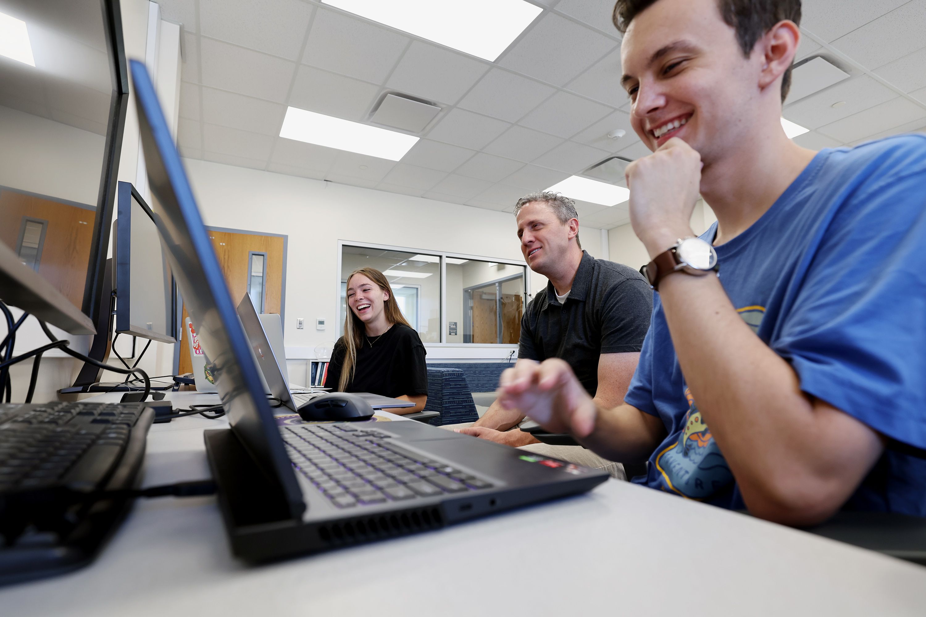 Associate professor David Wingate sits with students Brianna White, left, and Davis Foster, right, as BYU students work in the Perception, Control and Cognition lab at BYU on June 30. BYU students will this fall be able to major in machine learning — the technology behind ChatGPT.