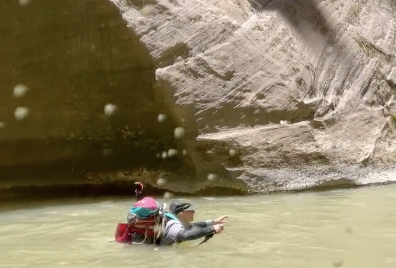 A hiker treks through the Virgin River in the Narrows on Friday. The route reopened on June 19, but Zion National Park rangers say the trail can still be "challenging" because of the current river flows. 