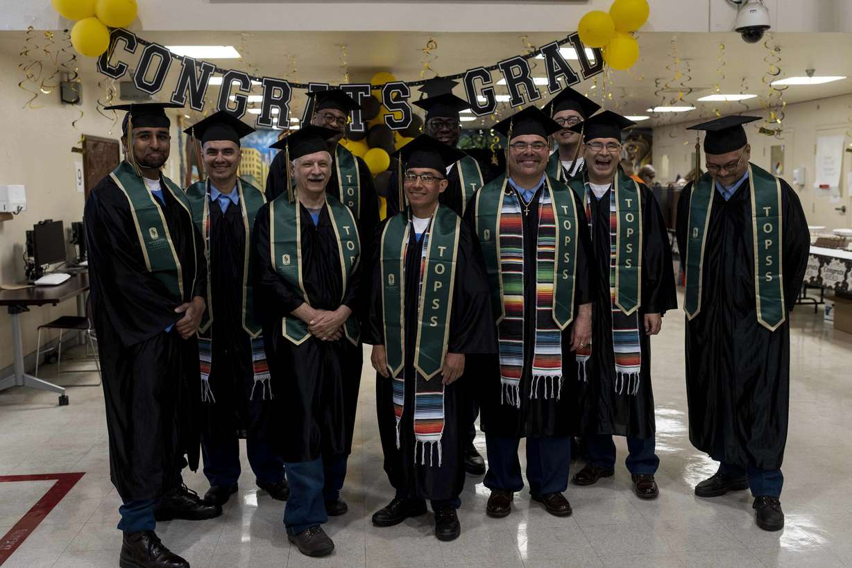 Incarcerated graduates, who finished their bachelor's degree program in communications through the Transforming Outcomes Project at Sacramento State (TOPSS), stand for a group photo in their cap and gowns before their graduation ceremony at Folsom State Prison in Folsom, Calif. on May 25, 2023.