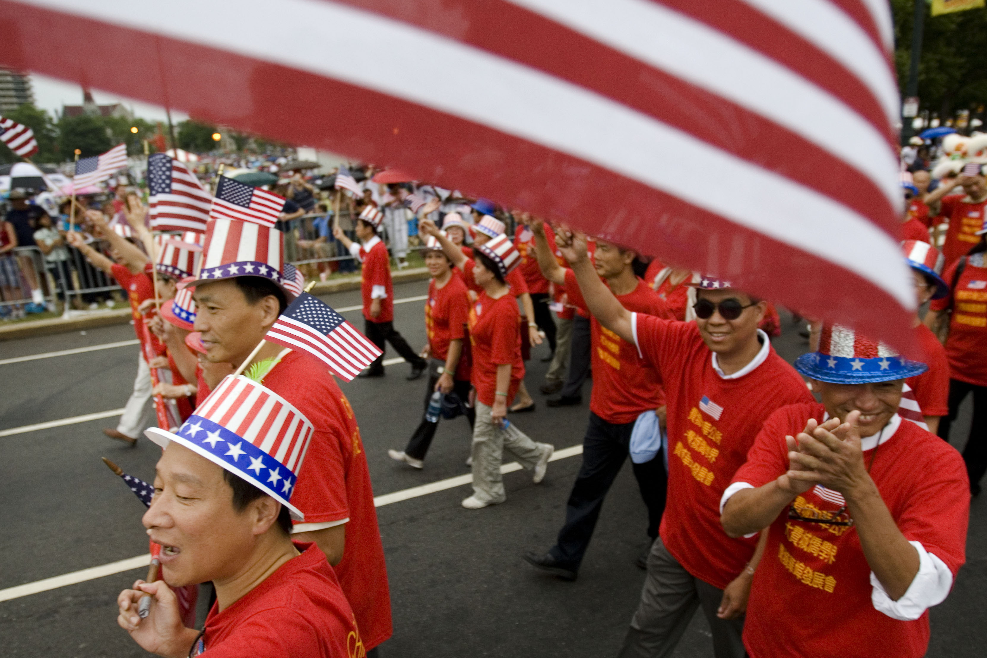 Tang De Wong, lower left, and other members of the Chinese Benevolent Association march in an Independence Day parade in Philadelphia on July 4, 2008. Flags proliferate every July Fourth, but it wasn't always a revered and debated symbol. 