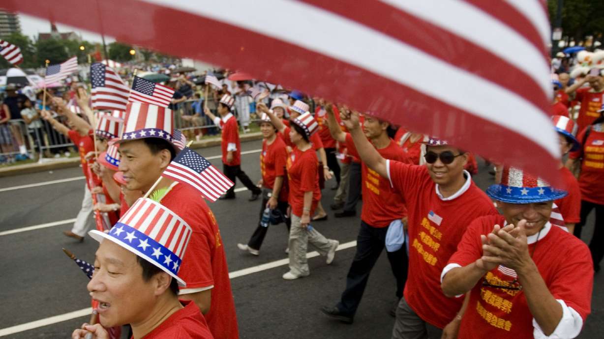 Tang De Wong, lower left, and other members of the Chinese Benevolent Association march in an Independence Day parade in Philadelphia on July 4, 2008. Flags proliferate every July Fourth, but it wasn't always a revered and debated symbol.