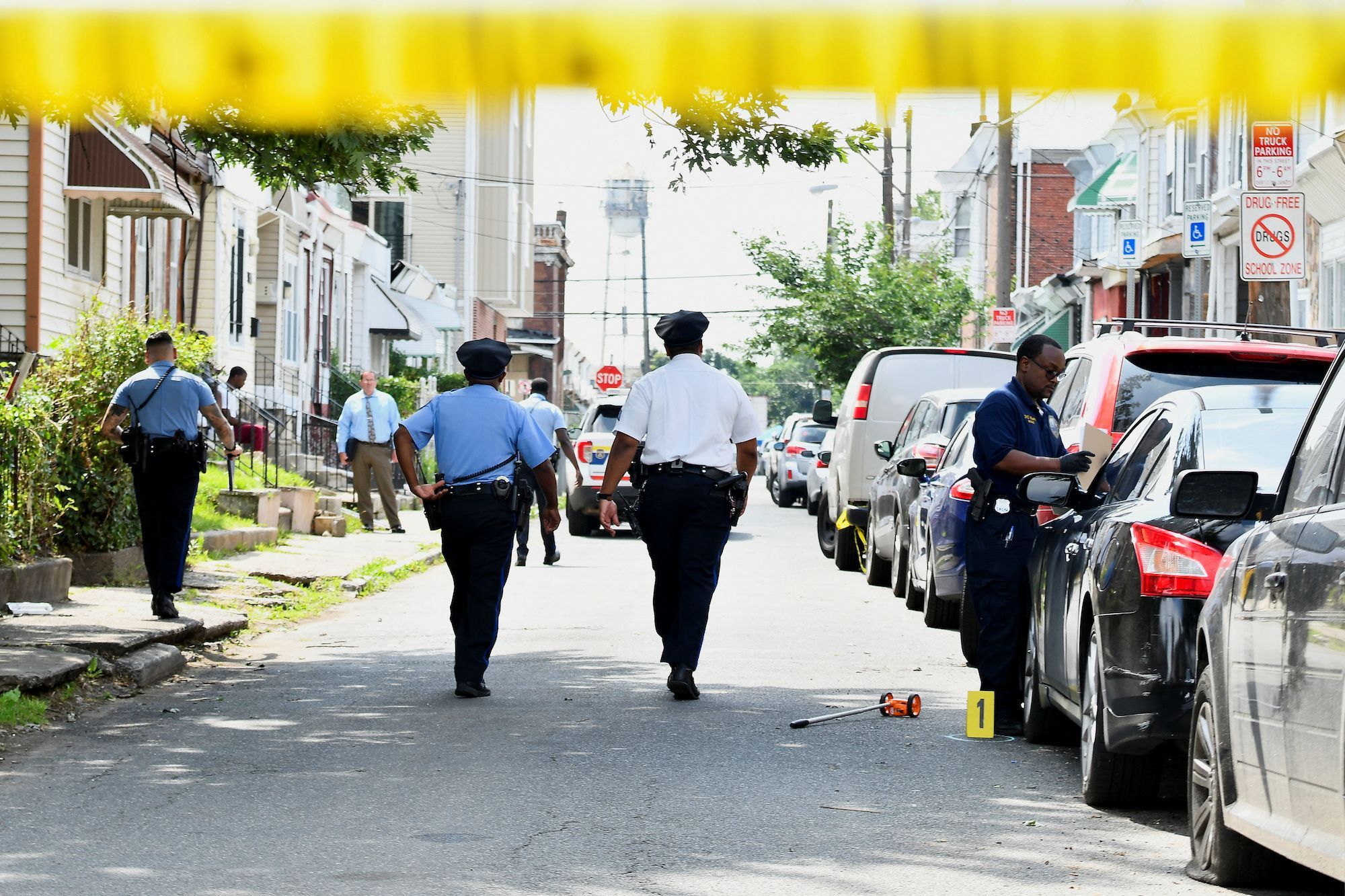 Police officers on July 4 investigate the scene of Monday night's mass shooting in southwest Philadelphia.