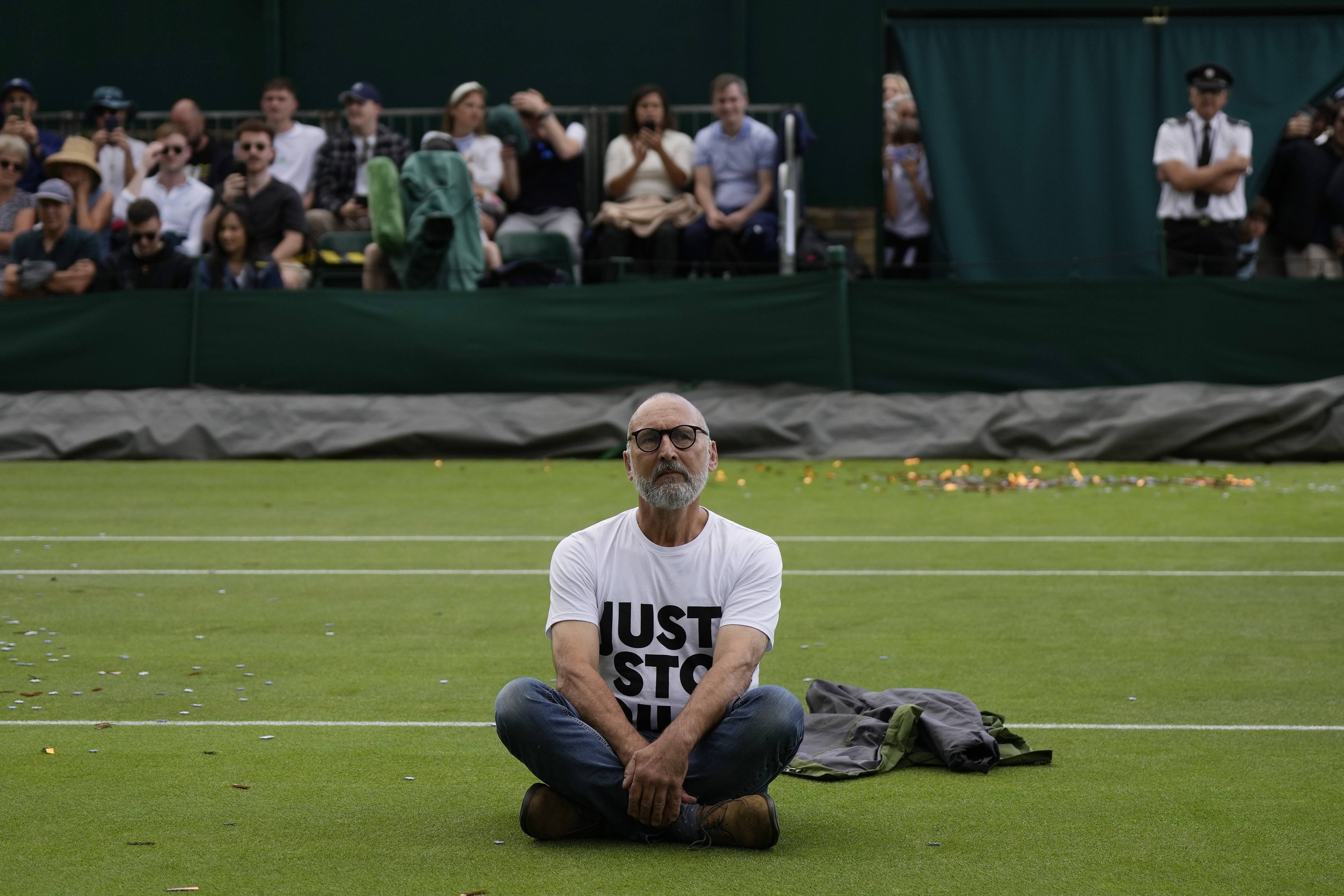 A Just Stop Oil protester sits on Court 18 on day three of the Wimbledon tennis championships in London, Wednesday, July 5, 2023. 