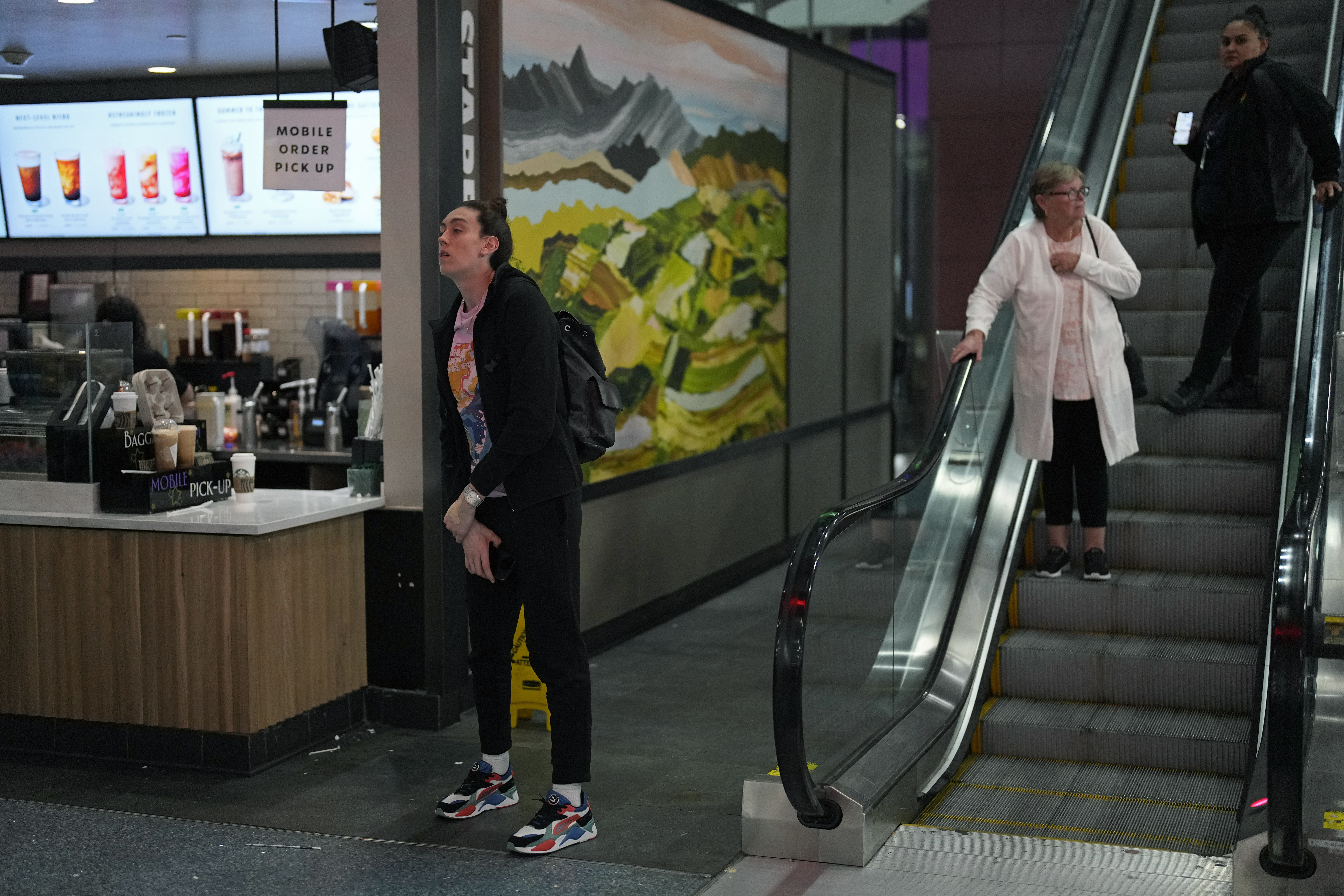 Breanna Stewart, left, of the New York Liberty WNBA basketball team waits for coffee after traveling for most of the day at Harry Reid International Airport while traveling with the team Wednesday, June 28, 2023, in Las Vegas. 