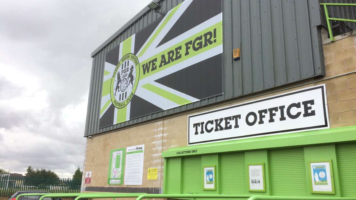 FILE - Signage hangs above the ticket office at the New Lawn, Forest Green Rovers' football ground, in Nailsworth, England. While women’s soccer is growing in popularity in the U.K. - opportunities for women in men’s game remain few and far between. That changed this week when Forest Green Rovers became the first professional soccer team in England to appoint a female head coach.