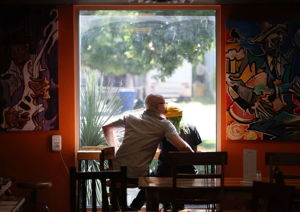 Bryce Draper and Noel Littlefield sit in Mestizo Coffeehouse in Salt Lake City on June 23. The business could be impacted by a potential expansion of I-15 in the area.