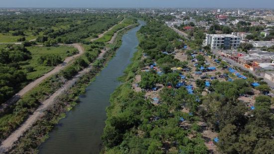 A makeshift camp, where asylum seekers wait as they attempt to cross into the U.S. by an appointment through the Customs and Border Protection app, called CBP One, lines the Rio Grande river border between Brownsville, Texas, and Matamoros, in Matamoros, Mexico, June 20.