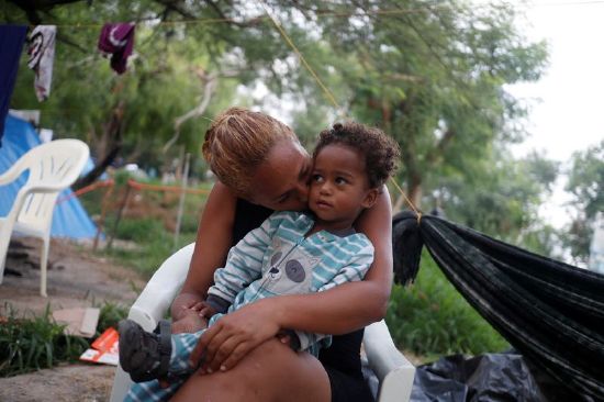 Venezuelan asylum seeker Alejandra Pena, 34, kisses her son Natanael, 1, next to their tent, while they wait to attempt to cross into the U.S. by an appointment through the Customs and Border Protection app, called CBP One, at a makeshift camp, in Matamoros, Mexico, June 20.