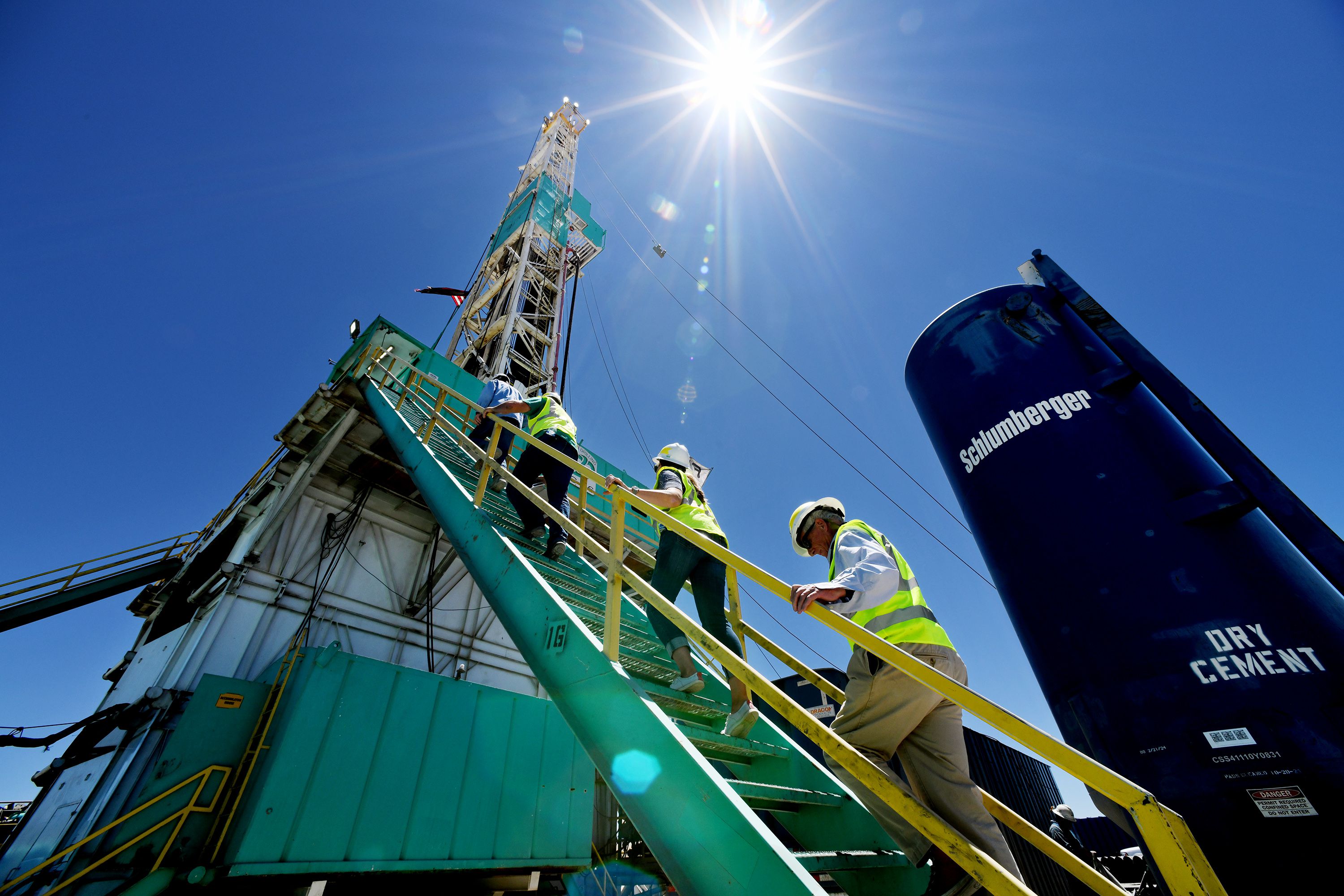 A group of media members climb the steps to the working deck as they take part in a tour of a drilling rig at the FORGE geothermal demonstration sight near Milford on Thursday.