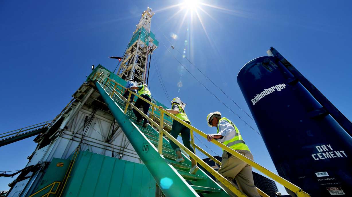 A group of media members climb the steps to the working deck as they take part in a tour of a drilling rig at the FORGE geothermal demonstration sight near Milford on Thursday.