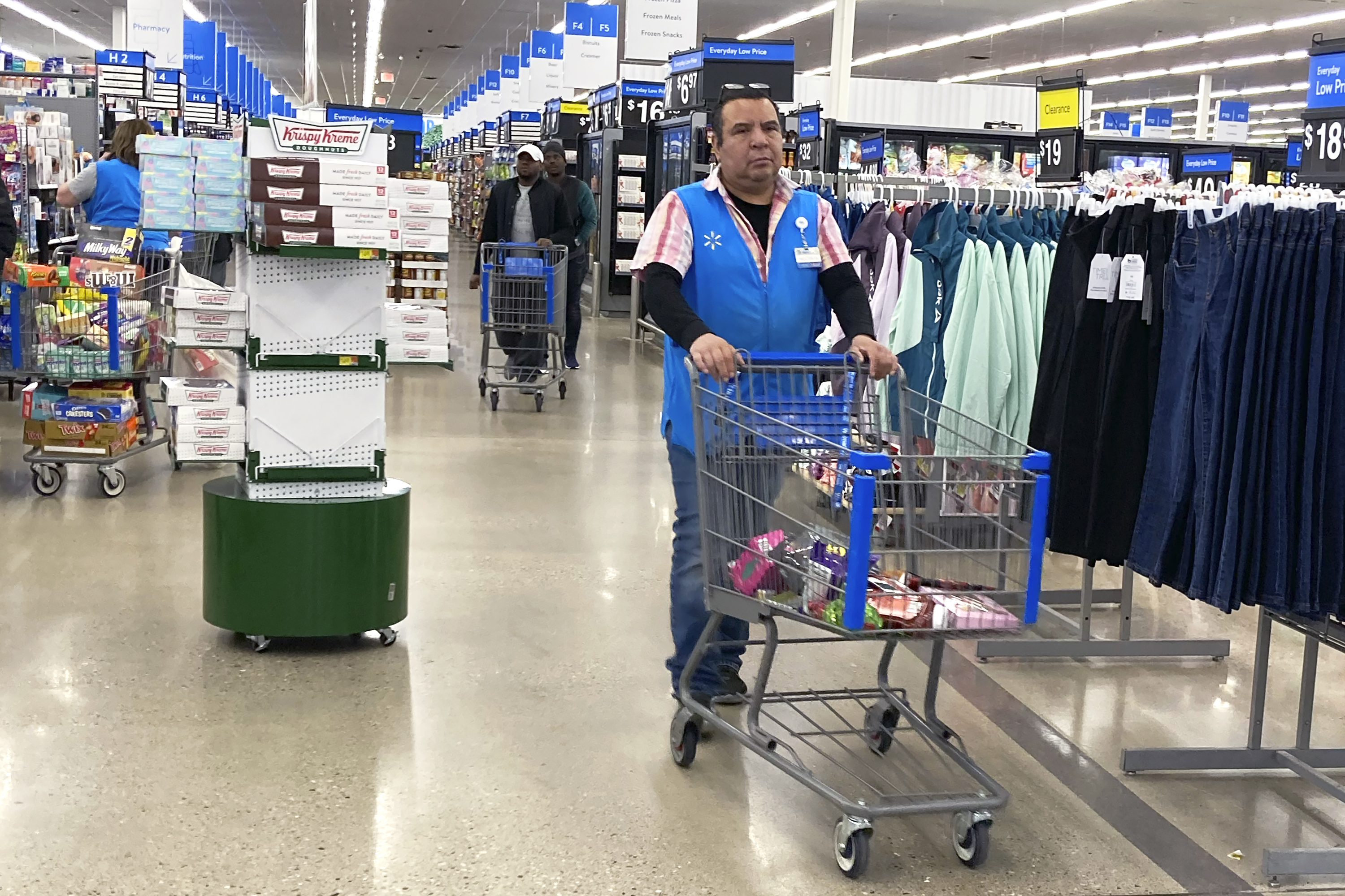 An employee pushes a cart at a Walmart in Vernon Hills, Ill., March 28. On Friday, the U.S. government issued the June jobs report.