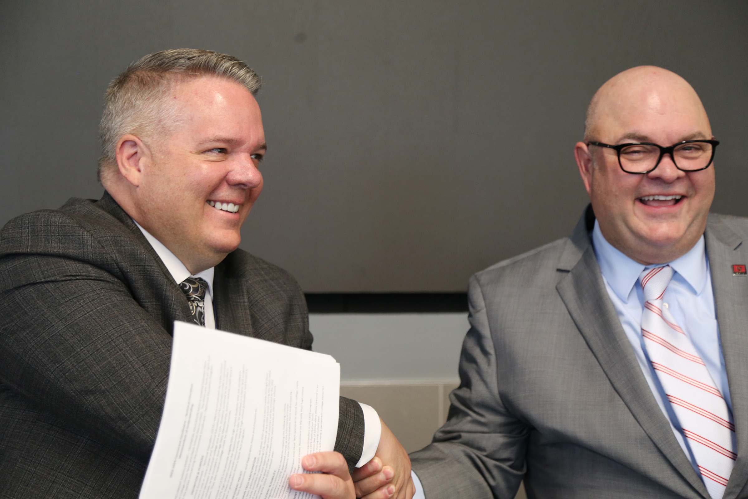 Davis School District superintendent Dan Linford, left, shakes hands with Davis Tech president Darin Brush during the signing of a concurrent enrollment agreement between the the district and the college on Thursday.