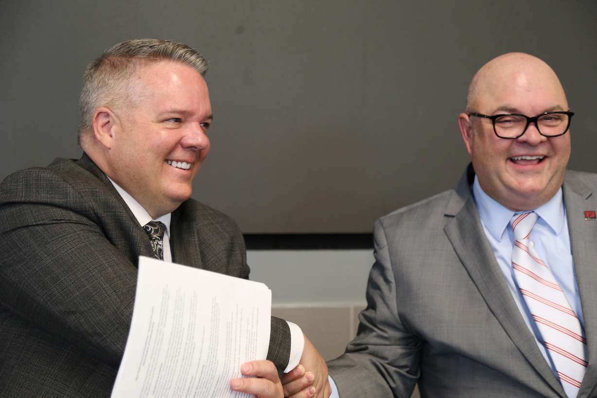 Davis School District superintendent Dan Linford, left, shakes hands with Davis Tech president Darin Brush during the signing of a concurrent enrollment agreement between the the district and the college on Thursday.