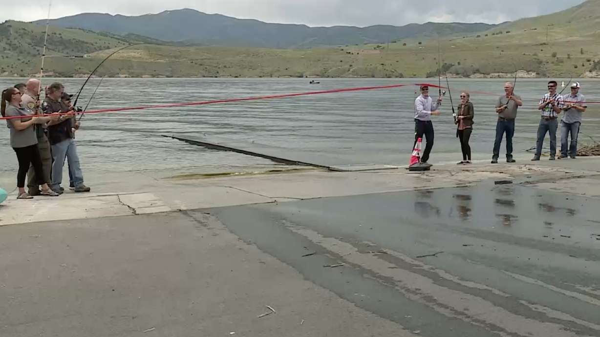 Utah state parks officials and others use fishing poles to rip apart a ribbon at the Echo Reservoir boating ramp at Echo State Park in Coalville on Thursday. The park has undergone multiple renovations since becoming a state park in 2018.