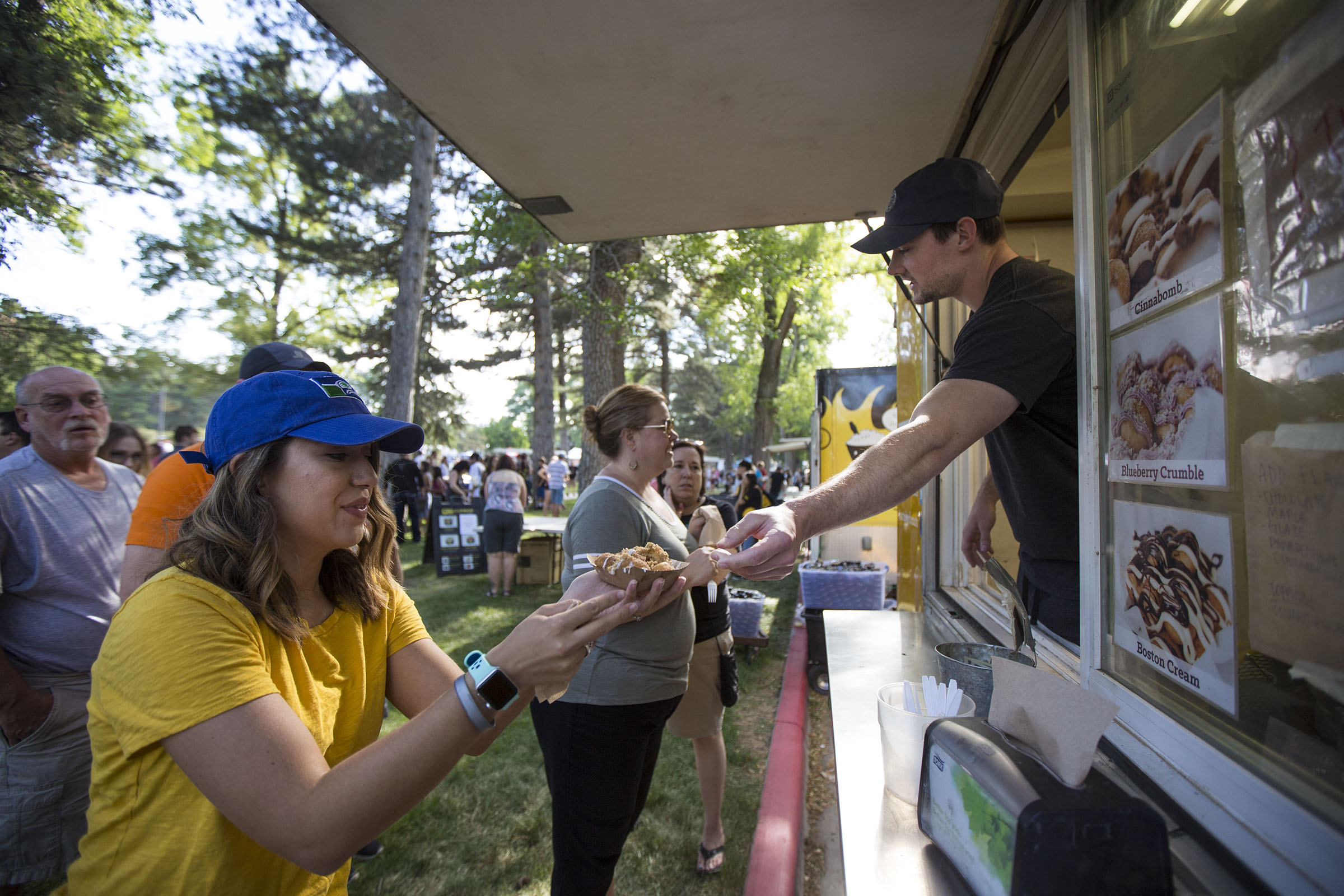 Emily Farnsworth, left, grabs a Boston cream dessert from the Art City Donut Truck during the Food Truck Face-Off for Charity on June 10, 2017. This year's event is set for Saturday in Liberty Park.