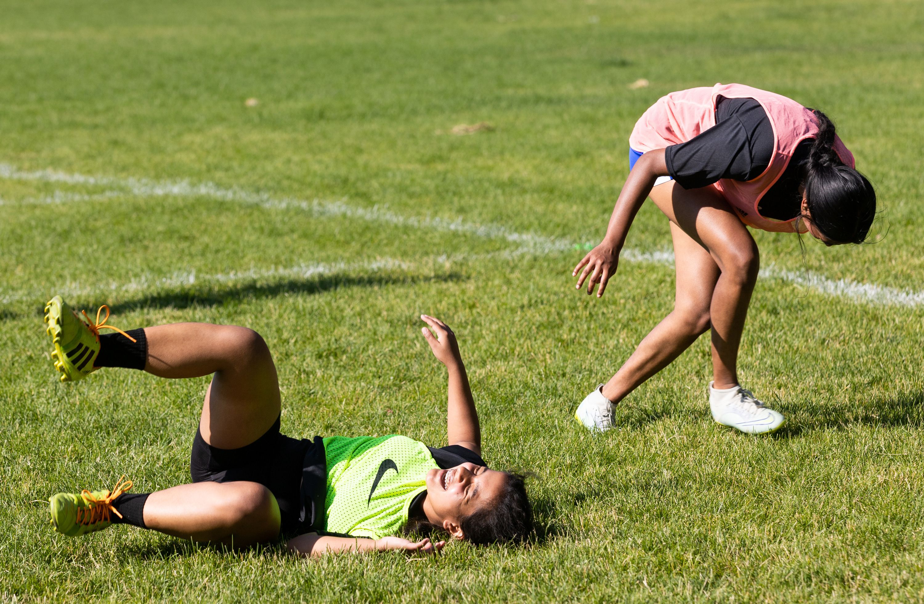 Romisha Adhikari, of Nepal, left, and Anu Arumugarasa, of Sri Lanka, laugh during a scrimmage at their #SheBelongs soccer practice at Lone Peak Park in Sandy on Thursday. #SheBelongs is a four-month program bringing together refugee and nonrefugee girls through soccer.