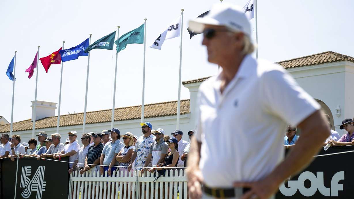 Fans watch as LIV Golf CEO Greg Norman looks on from the driving range before the first round of an LIV golf tournament at the Real Club Valderrama in San Roque, Spain, Friday, June 30, 2023.