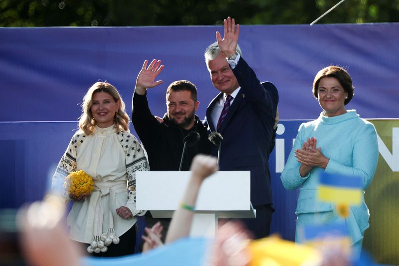 Ukrainian President Volodymyr Zelenskiy, his wife Olena Zelenska, Lithuanian President Gitanas Nauseda and his wife Diana Nausediene attend a ceremony during which a Ukrainian flag from the frontline of the war with Russia is delivered by activists, on the sidelines of a NATO leaders summit in Vilnius, Lithuania, on Tuesday.