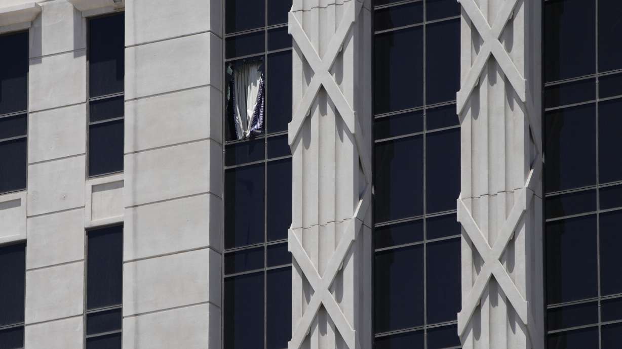 A curtain hangs out of a broken window on a hotel tower at Caesars Palace Hotel & Casino, Tuesday in Las Vegas. Las Vegas police say a man has taken a woman hostage at the Caesars Palace Hotel & Casino.