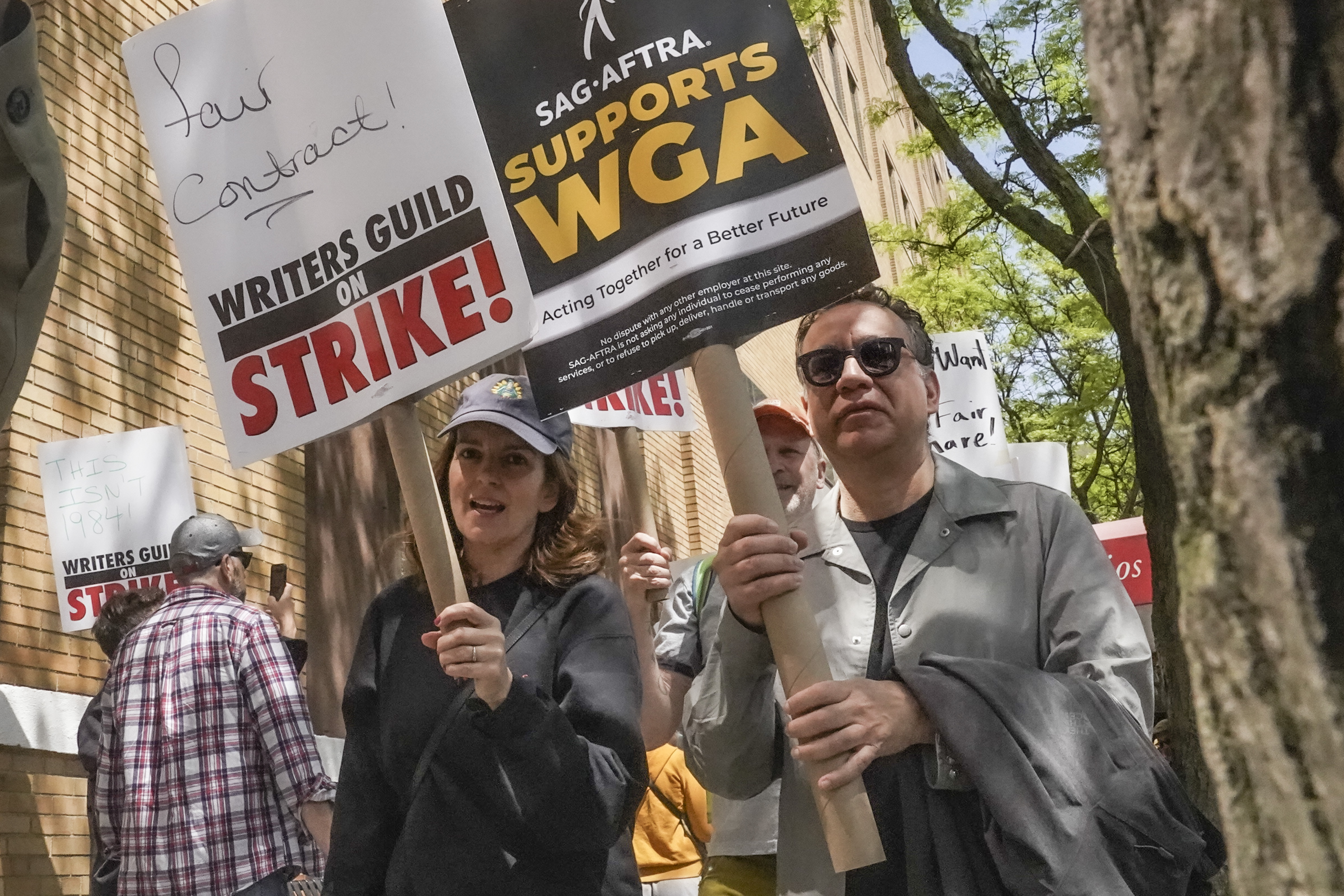 Actors and comedians Tina Fey, center, and Fred Armisen, right, picket with others outside Silvercup Studios May 9, in New York. The union representing film and television actors says it will strike.