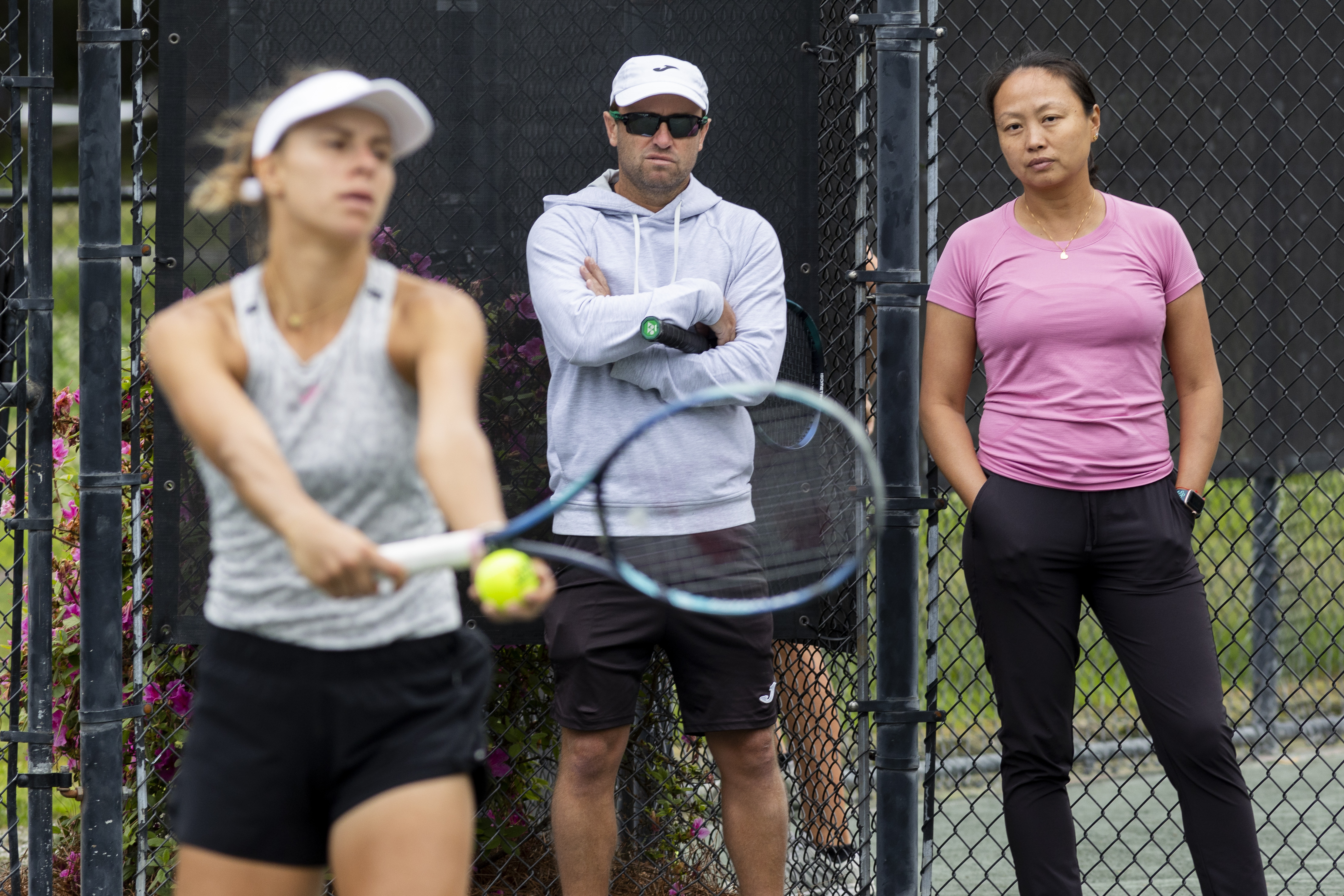 Lan Yao-Gallop and coach Mark Gellard, center, watch as Magda Linette prepares to serve on a practice court at the Charleston Open tennis tournament in Charleston, S.C., Monday, April 3, 2023. Yao-Gallop is a member of the women’s professional tennis tour’s Coach Inclusion Program to develop female coaches.