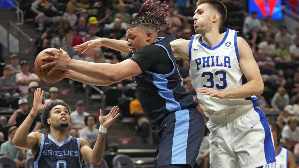 Memphis Grizzlies forward Kenneth Lofton Jr., center, pulls down a rebound as Philadelphia 76ers center Filip Petrusev (33) defends in the second half during an NBA Summer League basketball game Monday, July 3, 2023, in Salt Lake City.