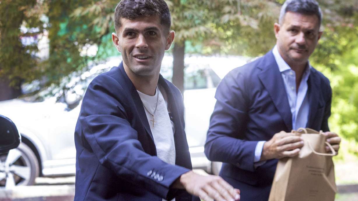 United States soccer player Christian Pulisic, front, waves as he arrives in Milan, Italy, Wednesday, July 12, 2023, for medical tests at Italian Serie A soccer team AC Milan before an expected transfer from British club FC Chelsea.
