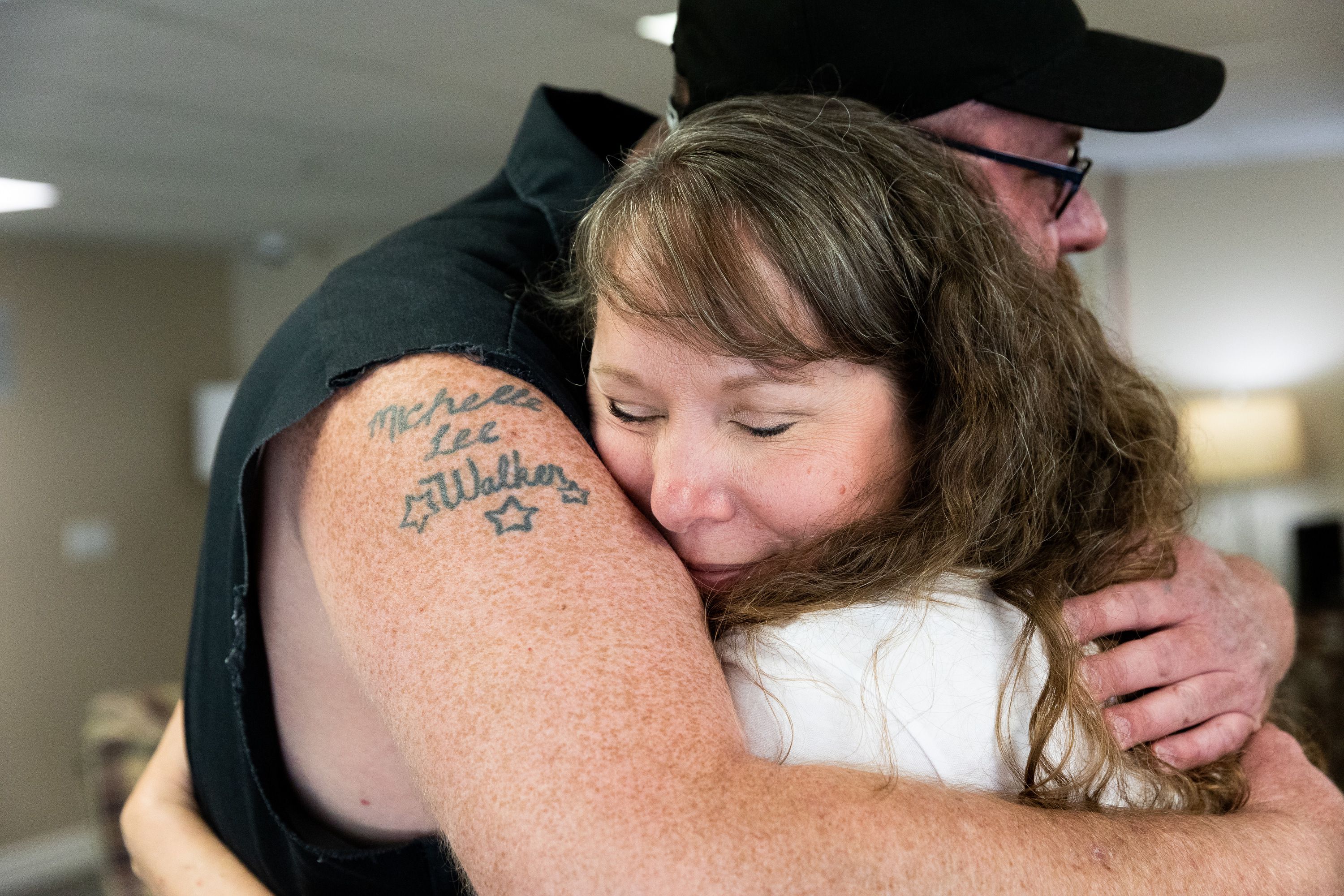 Tasha Cram hugs Mike Walker in Salt Lake City on July 8. After losing her twin at age 4, Cram is on a journey to give 1,000 healing hugs to twins across the U.S.