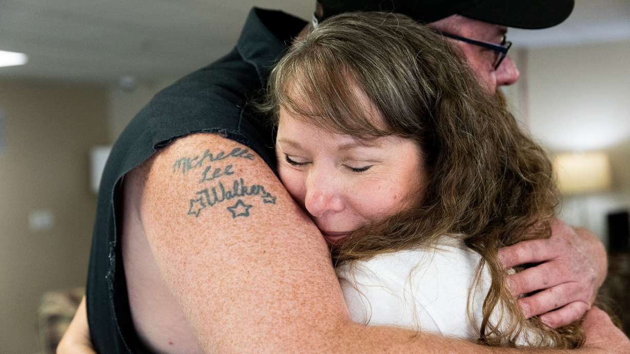 Tasha Cram hugs Mike Walker in Salt Lake City on July 8. After losing her twin at age 4, Cram is on a journey to give 1,000 healing hugs to twins across the U.S.