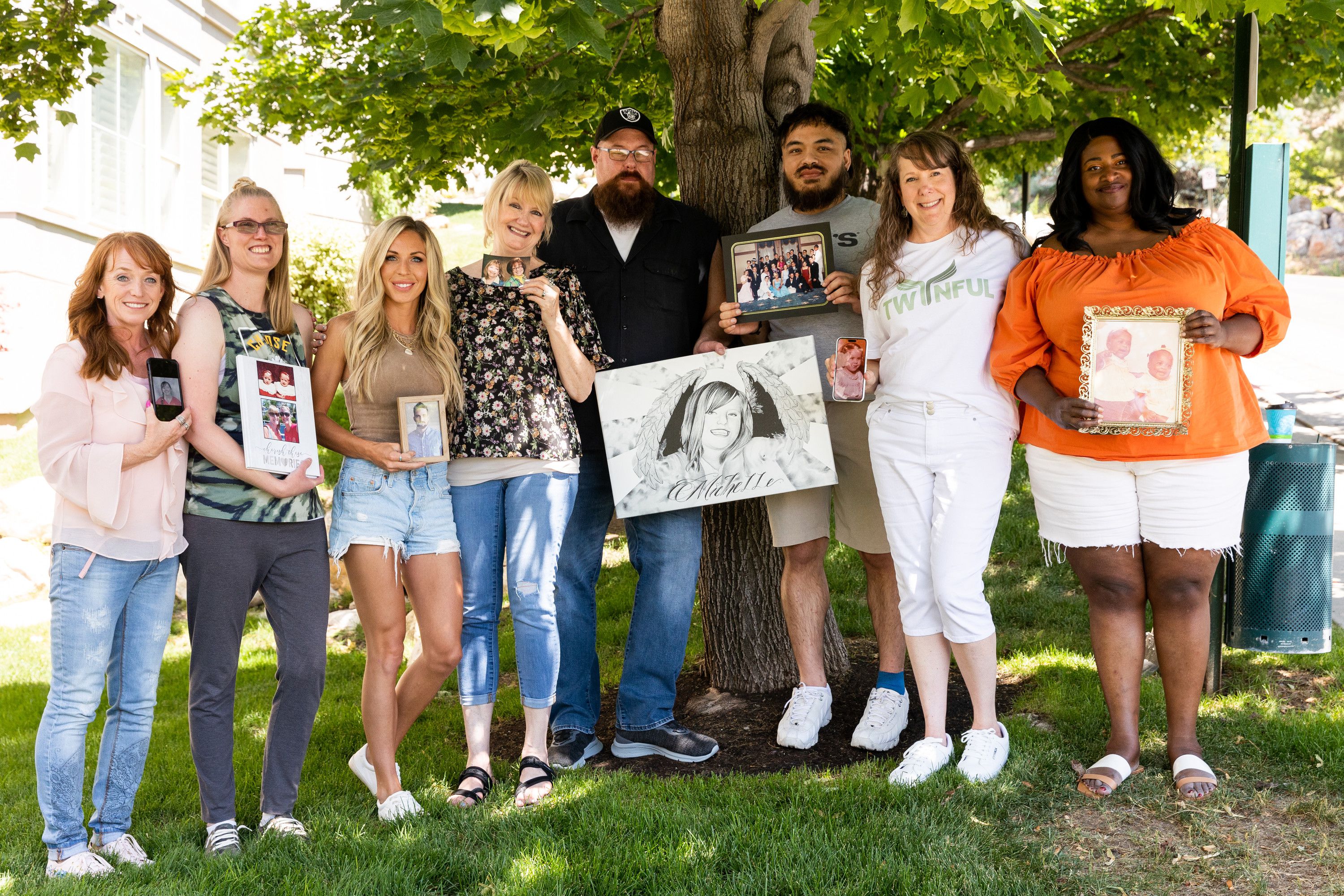 A group of twinless twins poses with photos of their twins at the Hug Tour stop at the Presidential Club Condos in Salt Lake City on July 8. After losing her twin at age 4, Tasha Cram is on a journey to hug 1,000 twins across the U.S.