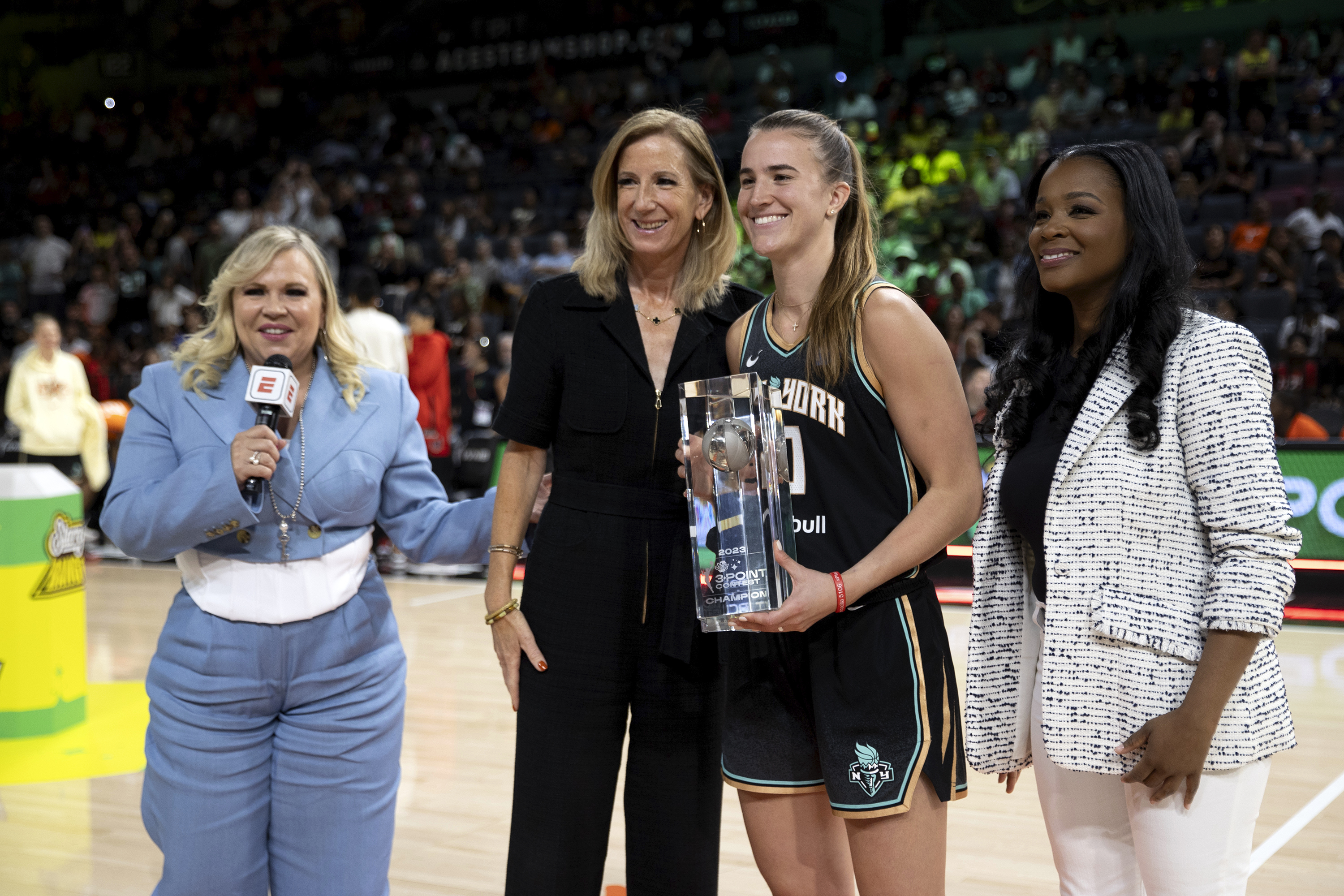 New York Liberty guard Sabrina Ionescu, center right, poses with WNBA Commissioner Cathy Englebert, center left, after winning the WNBA All-Star 3-point contest Friday, July 14, 2023, in Las Vegas. 
