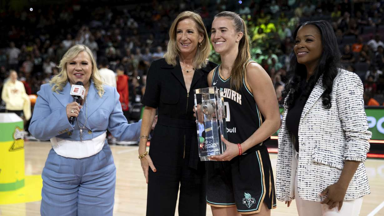 New York Liberty guard Sabrina Ionescu, center right, poses with WNBA Commissioner Cathy Englebert, center left, after winning the WNBA All-Star 3-point contest Friday, July 14, 2023, in Las Vegas.