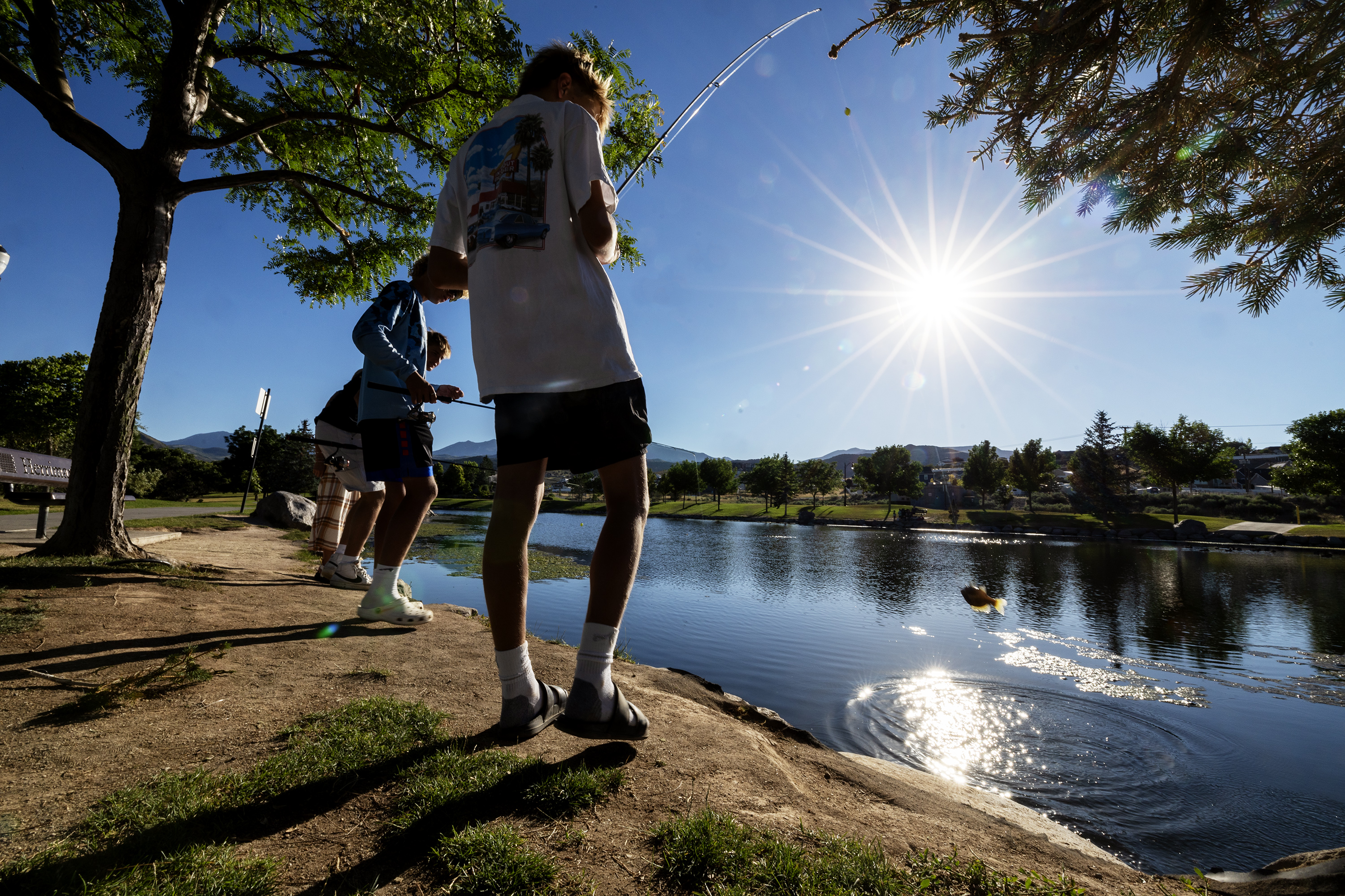 Creighton Barnes snags a fish as he and Carter Camp, Mason Barnes and Zoe Gutierrez fish at the Cove Pond in Herriman on Saturday. Extreme heat is expected Sunday and Monday.