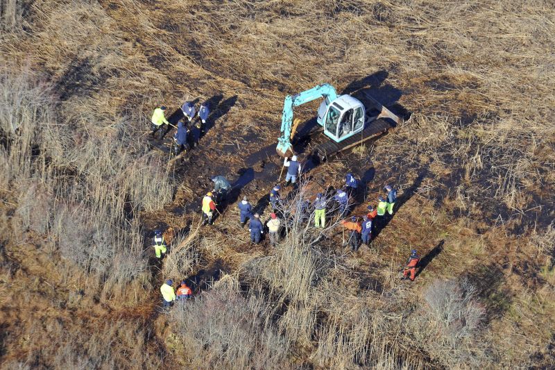 In this Dec. 8, 2011 photo, investigators use a backhoe to dig while searching for Shannan Gilbert's body in different sectors of a marsh area just east of Oak Beach, N.Y. A Long Island architect has been charged Friday with murder in the deaths of three of the 11 victims in a long-unsolved string of killings known as the Gilgo Beach murders.
