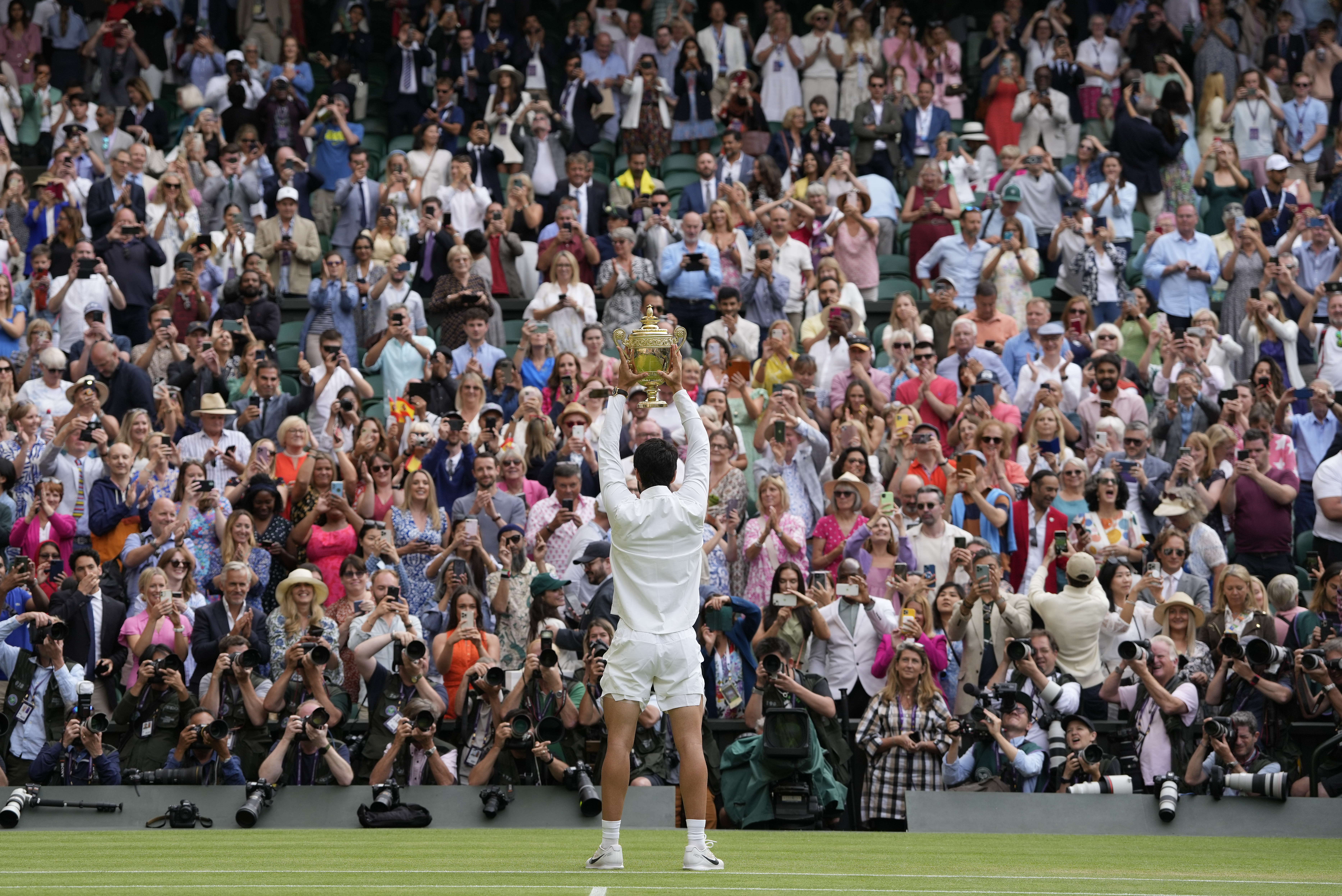 Spain's Carlos Alcaraz celebrates with the trophy after beating Serbia's Novak Djokovic to win the final of the men's singles on day fourteen of the Wimbledon tennis championships in London, Sunday, July 16, 2023. 