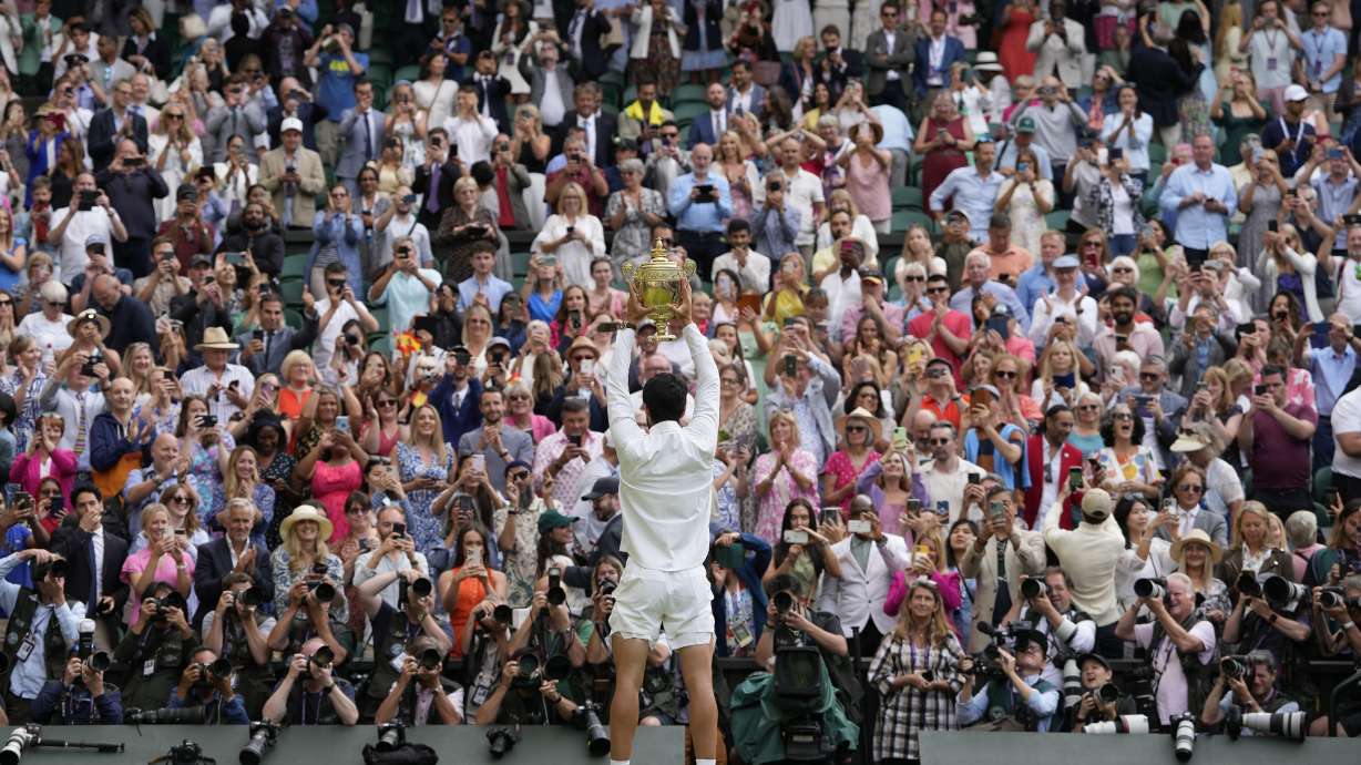 Spain's Carlos Alcaraz celebrates with the trophy after beating Serbia's Novak Djokovic to win the final of the men's singles on day fourteen of the Wimbledon tennis championships in London, Sunday, July 16, 2023.