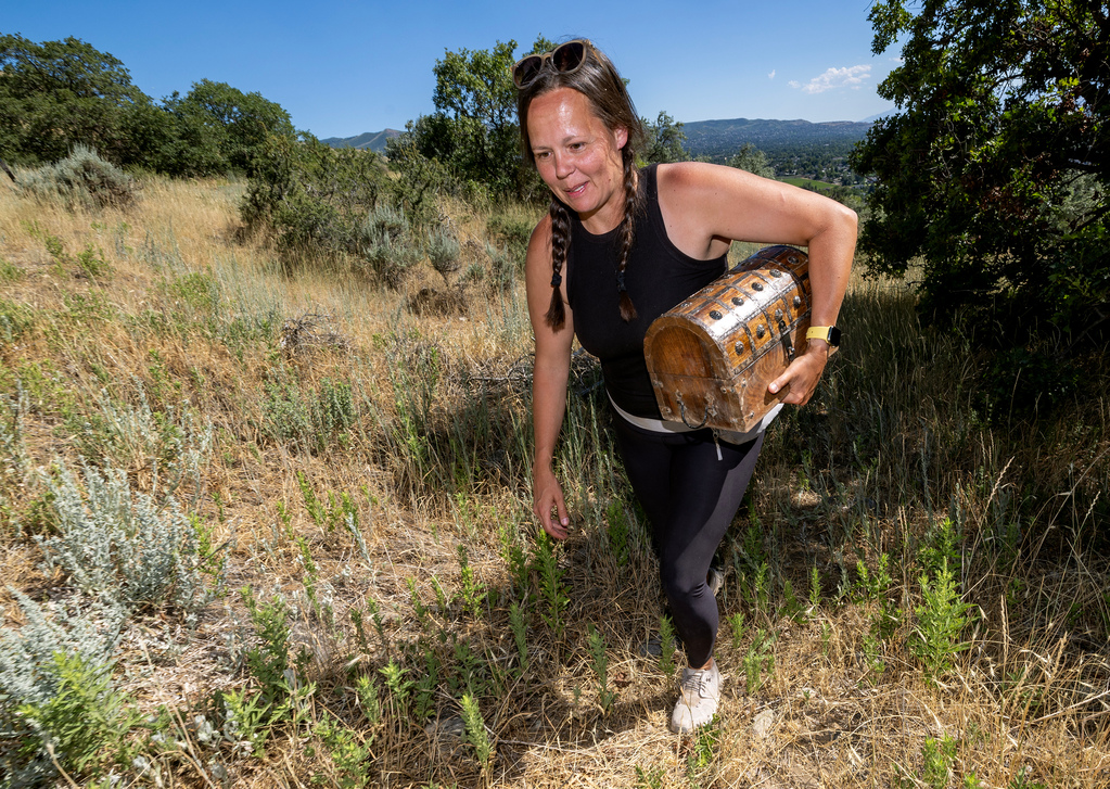 Chelsea Gotta of Pella, Iowa walks back to her car after posing posing with the trunk of money she found off Mueller Park Trail in the mountains east of Bountiful on Sunday. Gotta has been in Utah multiple times over the past weeks to search for the hidden treasure.