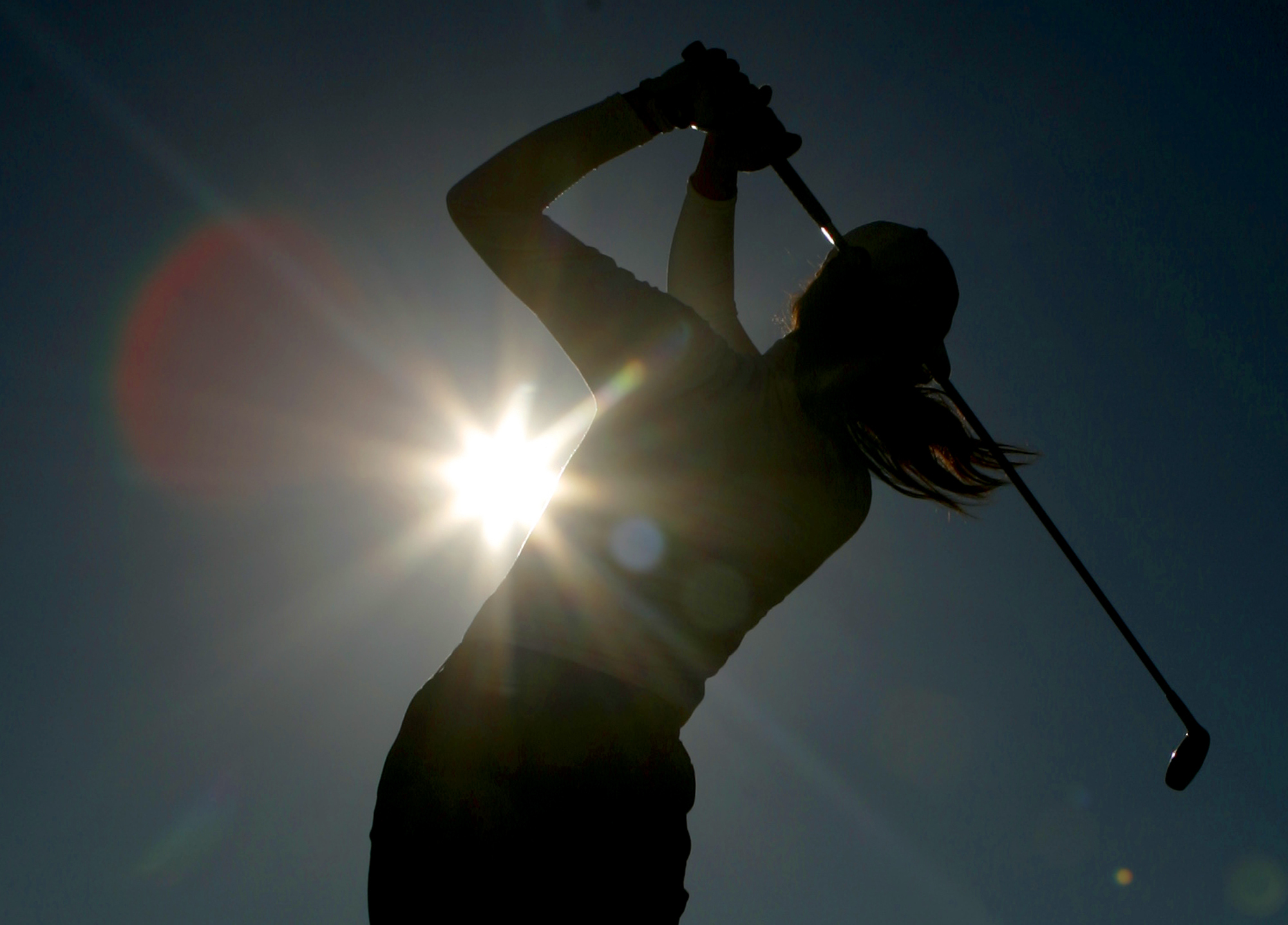 FILE - A golfer is silhouetted against the sun while teeing off on the third hole during the first round of the Women's British Open golf tournament at Royal Lytham and St Annes golf course in Lytham, north west England Thursday, Aug. 3, 2006. Kerry Bowie's daughters have dreams. Big ones. “There are some things people miss out on by not doing it,” Bowie says. “To be that young lady who plays golf, it changes things.”