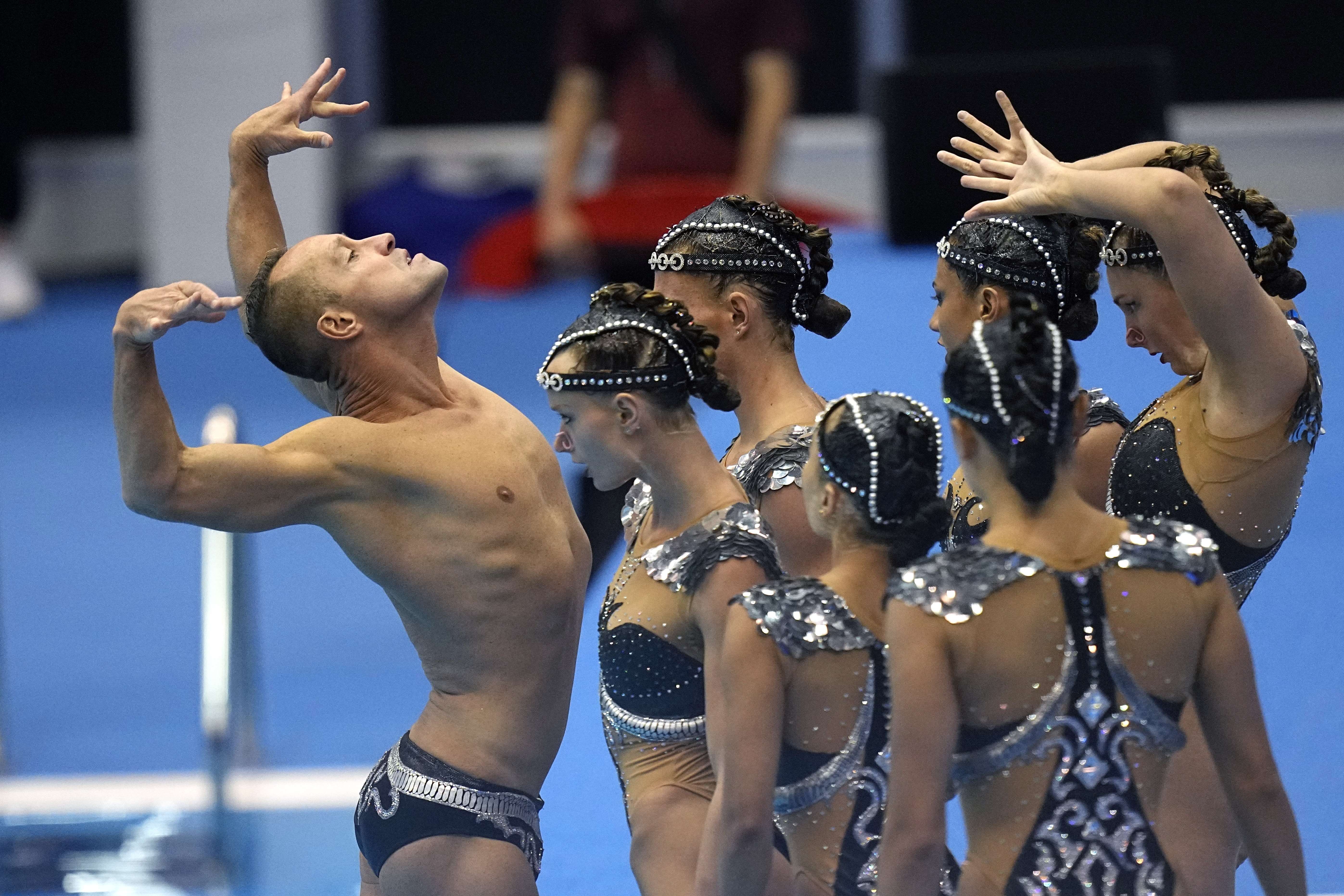 Bill May, left, leads the United States team out to compete in the team acrobatic of artistic swimming at the World Swimming Championships in Fukuoka, Japan, Saturday, July 15, 2023. Largely unoticed by the general public, men have been participating in artistic swimming, formerly known as synchronized swimming, for decades. 