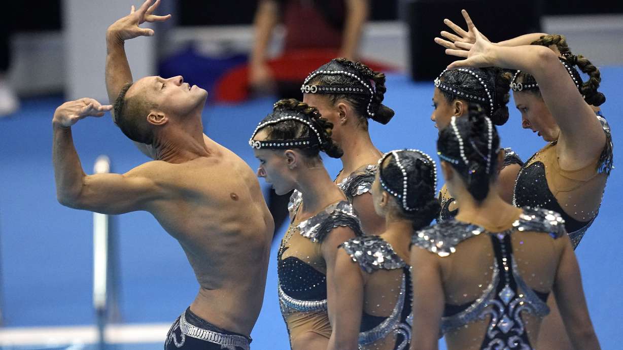 Bill May, left, leads the United States team out to compete in the team acrobatic of artistic swimming at the World Swimming Championships in Fukuoka, Japan, Saturday, July 15, 2023. Largely unoticed by the general public, men have been participating in artistic swimming, formerly known as synchronized swimming, for decades.