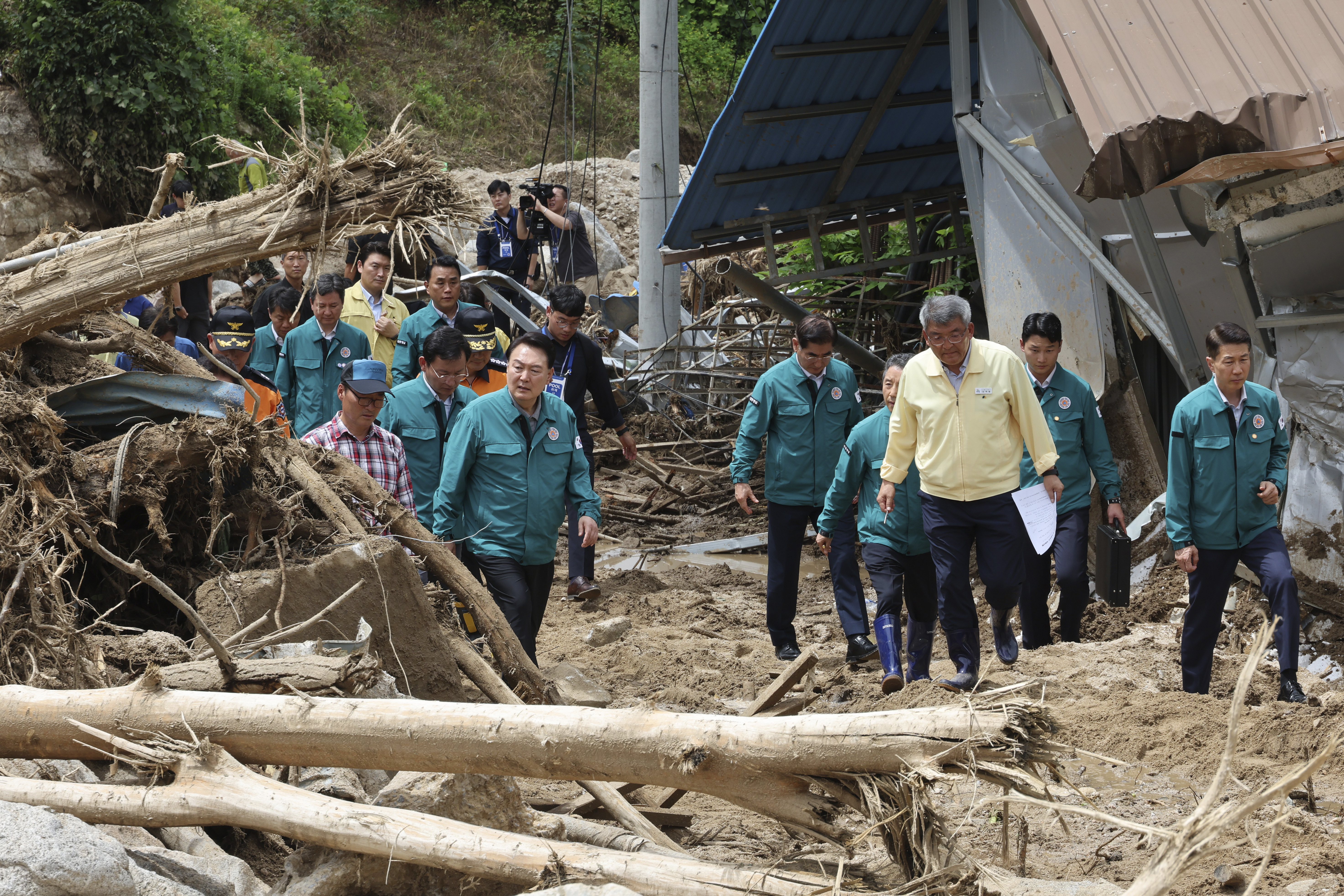South Korean President Yoon Suk Yeol, third from left, looks around a flood damaged area in Yecheon, South Korea, Monday. Heavy downpours lashed South Korea a ninth day on Monday as rescue workers struggled to search for survivors.