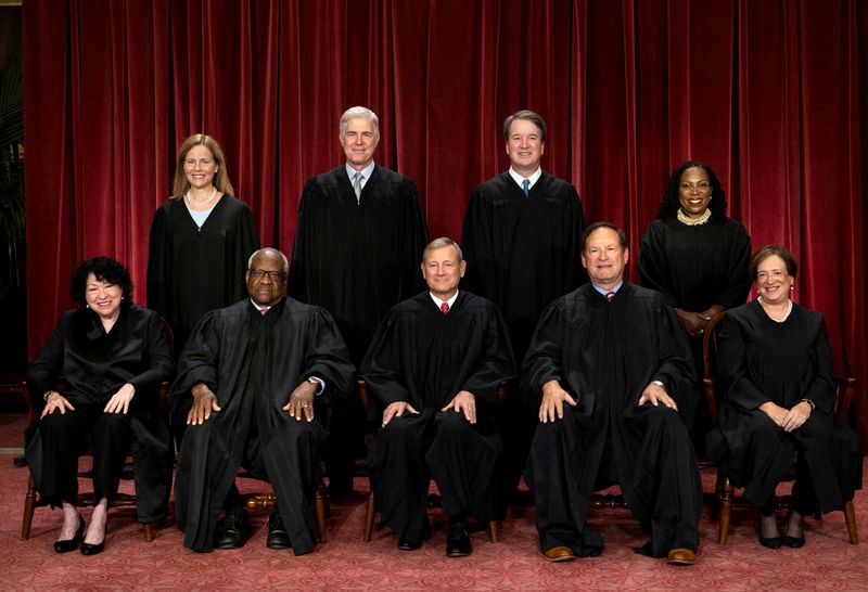 U.S. Supreme Court justices Amy Coney Barrett, Neil M. Gorsuch, Brett M. Kavanaugh, Ketanji Brown Jackson, Sonia Sotomayor, Clarence Thomas, Chief Justice John G. Roberts, Jr., Samuel A. Alito, Jr. and Elena Kagan pose for their group portrait at the Supreme Court in Washington, Oct. 7, 2022. Senate Democrats are pursuing legislation that would set a binding ethics code for the Court.