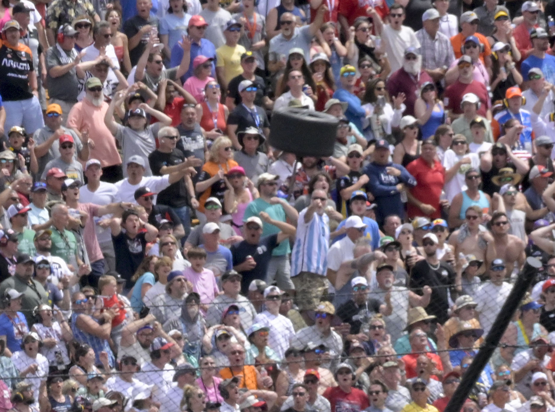 FILE - A wheel flies near a section of grandstand in the second turn after a collision between Kyle Kirkwood and Felix Rosenqvist during the 107th running of the Indianapolis 500, Sunday, May 28, 2023, at Indianapolis Motor Speedway in Indianapolis. IndyCar will implement a new, stronger piece of hardware designed to keep rear wheels attached to the car during a wreck after a tire flew off Kyle Kirkwood's car and narrowly missed a packed grandstand during the Indianapolis 500. The series said Wednesday, July 19, that chassis manufacturer Dallara had designed a retaining nut that is more than 60% stronger than the previous design. 