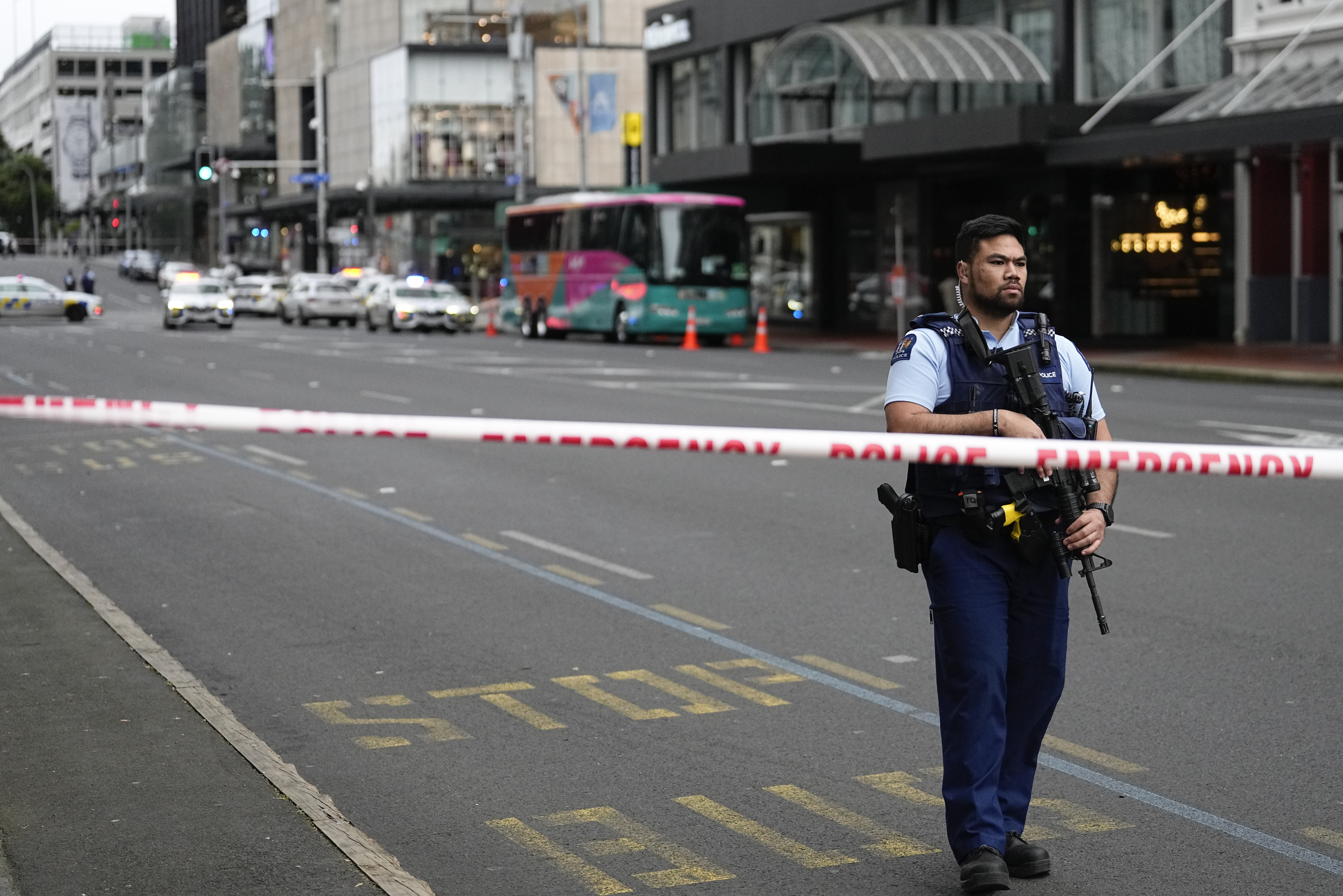 An armed New Zealand police officer stands at a road block in the central business district following a shooting in Auckland, New Zealand, Thursday, July 20, 2023. New Zealand police are responding to reports that a gunman has fired shots in a building in downtown Auckland. 