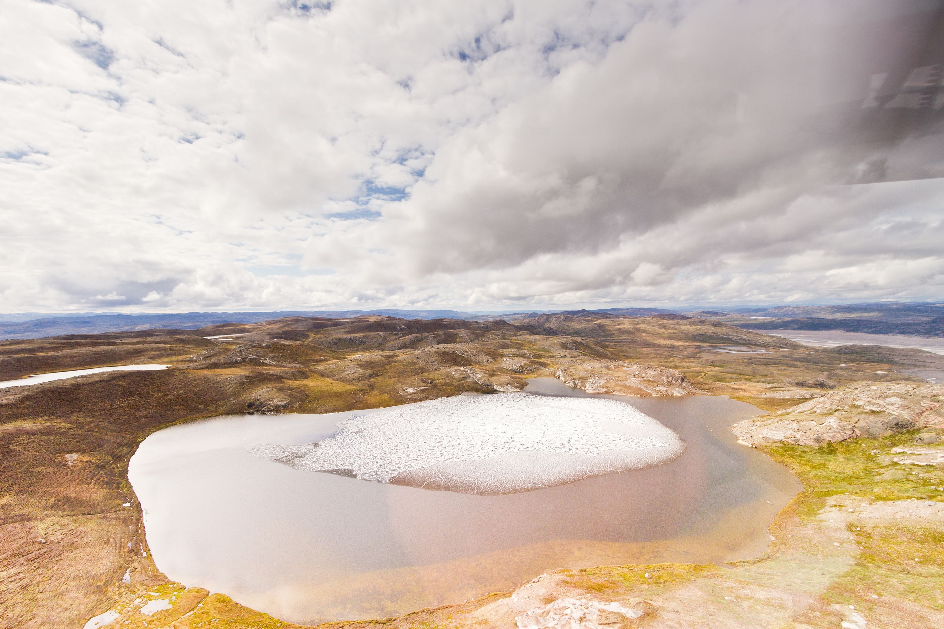 Melting ice is seen on a small tundra pond in Greenland. A recently discovered ice core taken from beneath Greenland's ice sheet decades ago has revealed that a large part of the country was ice-free around 400,000 years ago, when temperatures were similar to those the world is approaching now, according to a new report.