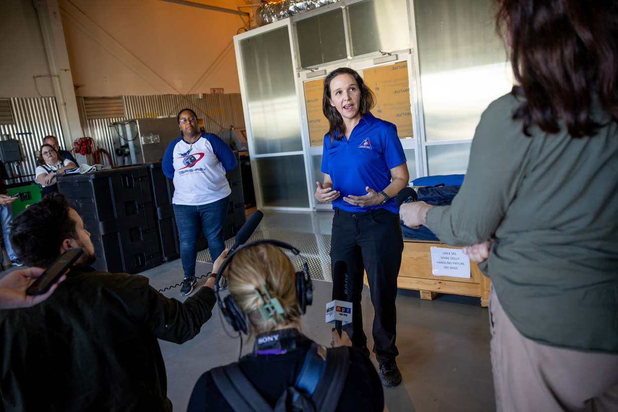 Kimberly Allums, OSIRIS-REx curation project lead, back left, and Nicole Lunning, lead sample curator for OSIRIS-REx, talk to journalists outside a cleanroom at Dugway Proving Grounds on Thursday.