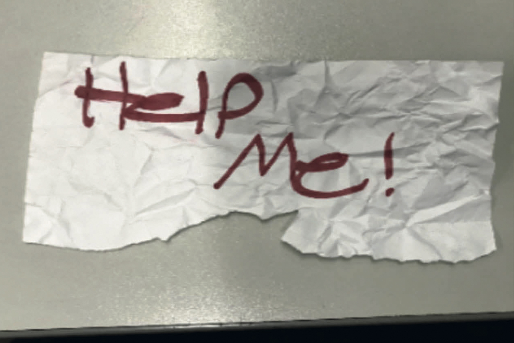 A photo shows the "Help Me!" sign used by a 13-year-old girl kidnapped in Texas. The girl was rescued in Southern California on July 9 when passersby saw her hold up the sign in a parked car, police said.